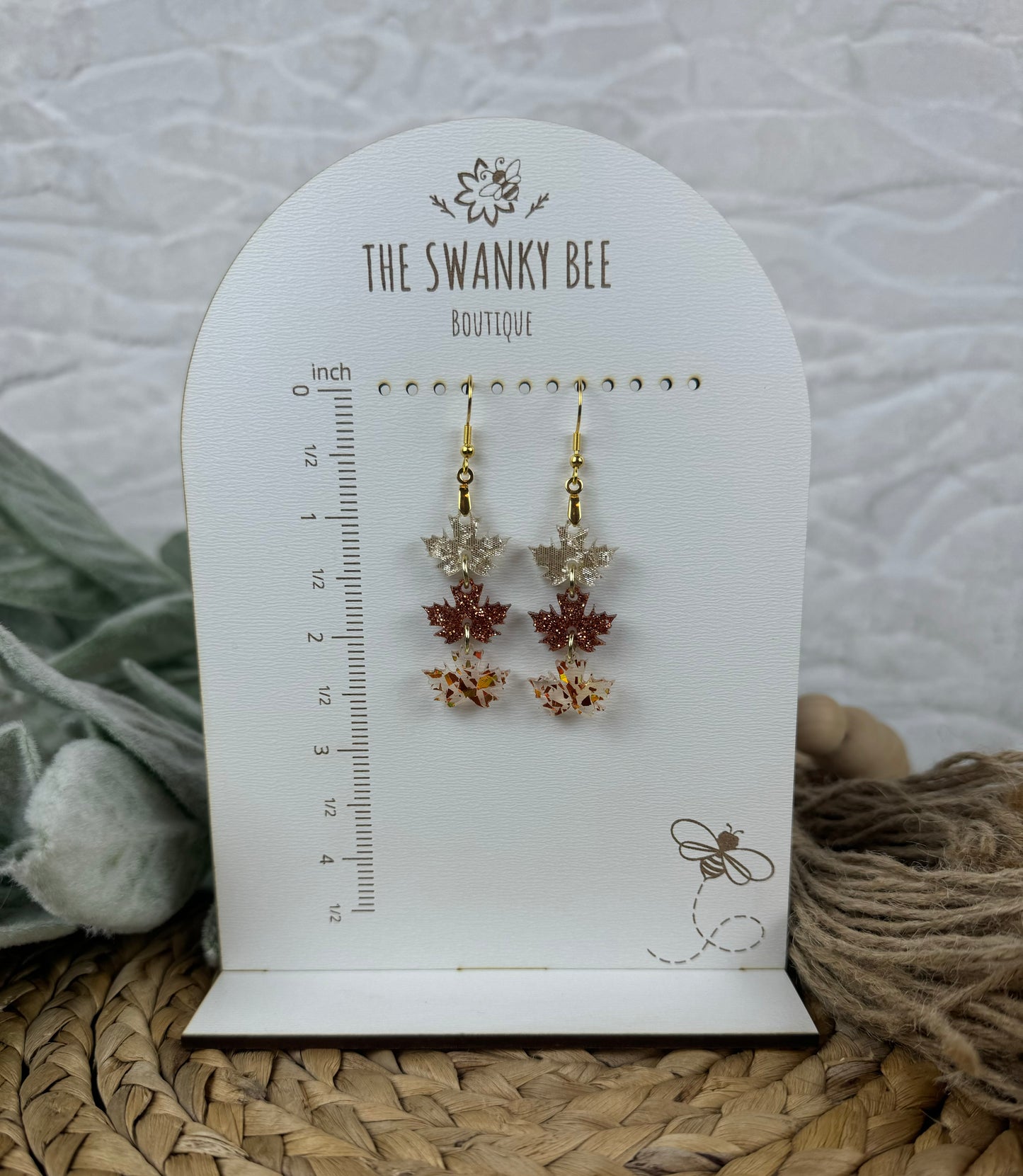 Elegant leaf earrings on display stand