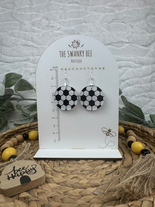 Stylish soccer dangle earrings displayed on a branded card with a ruler guide, featuring black and white soccer ball patterns, perfect for sports enthusiasts.