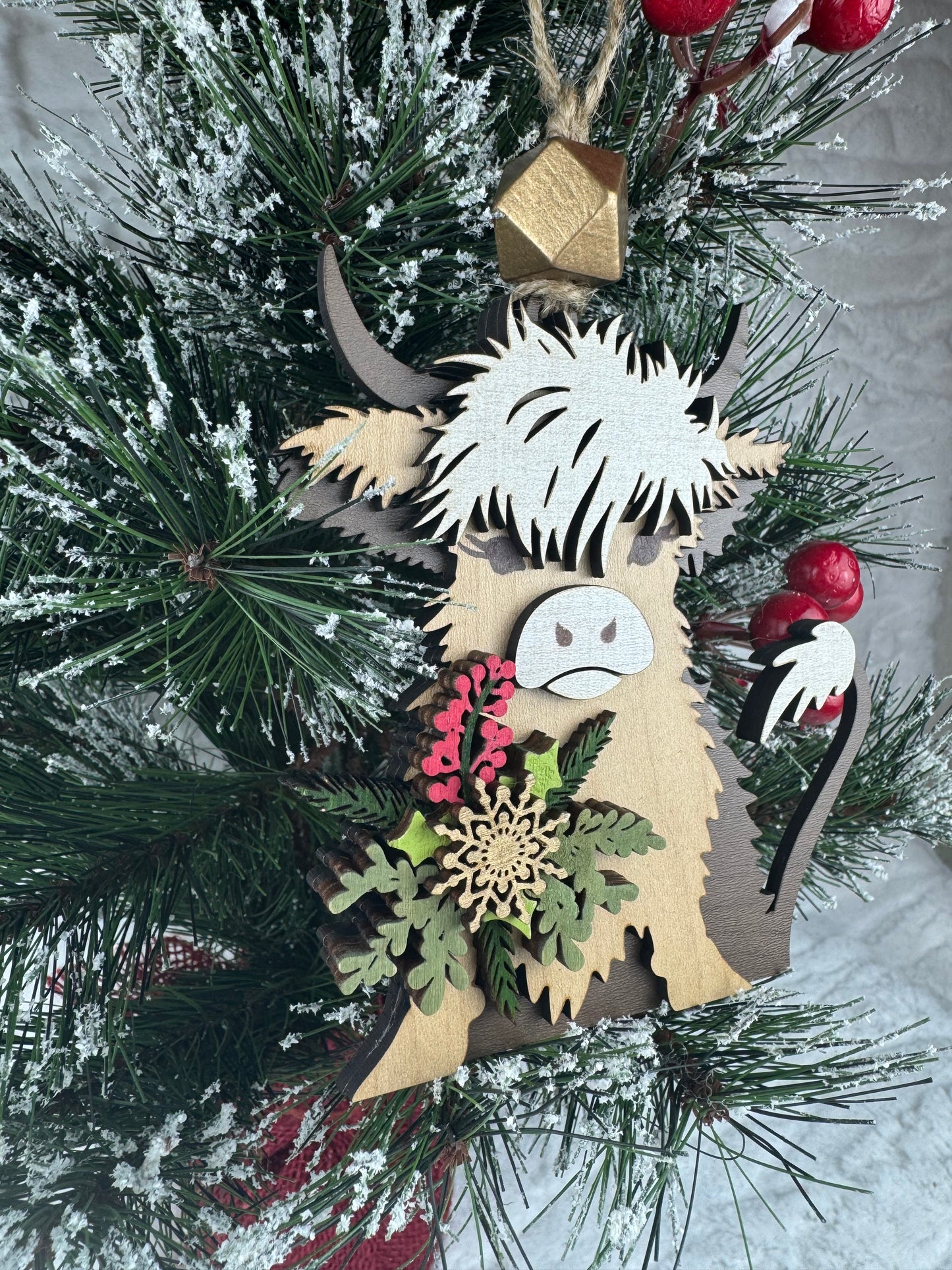 Wooden Highland Cow ornament with holiday greenery