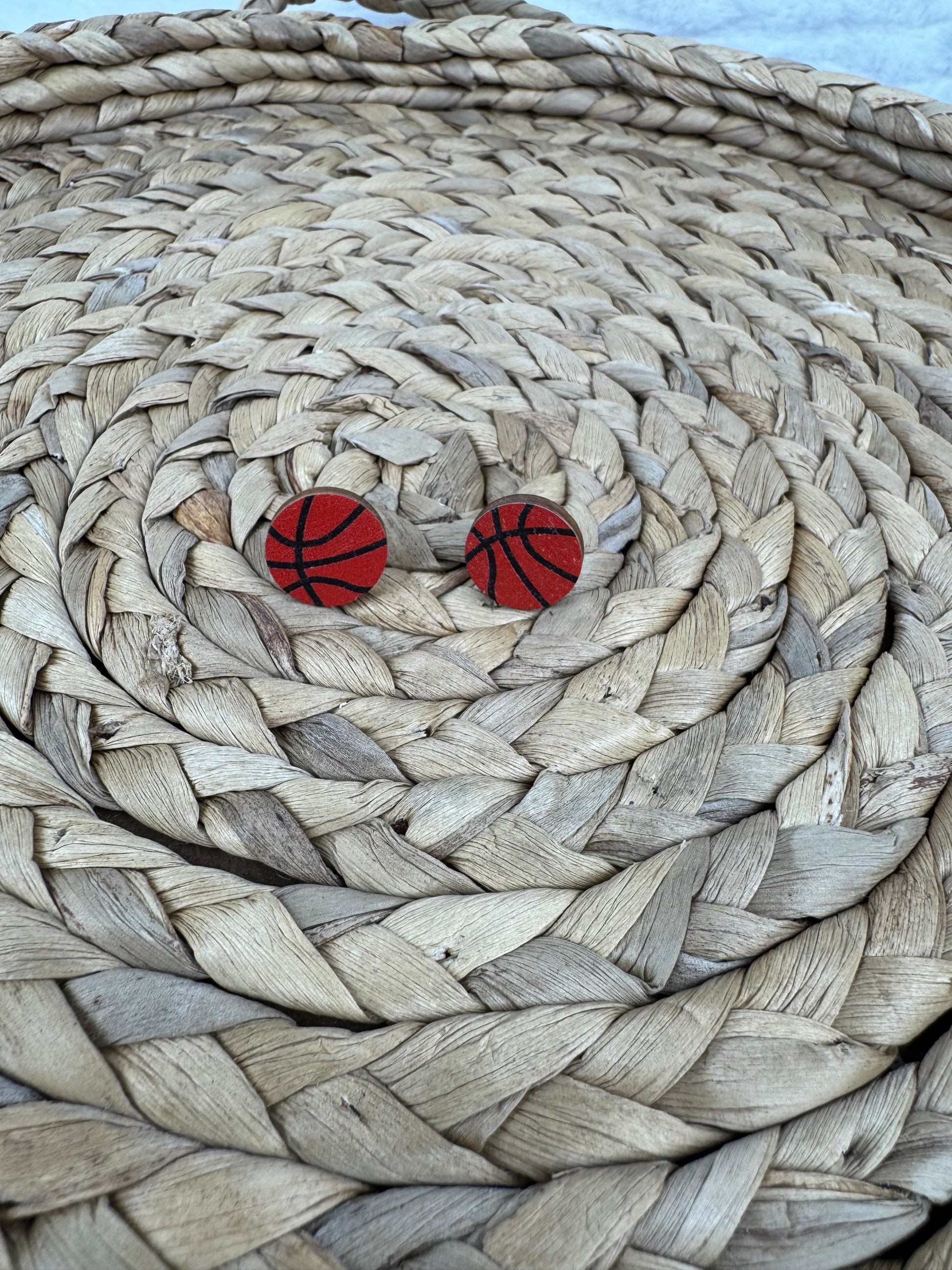 Basketball studs earrings on woven mat