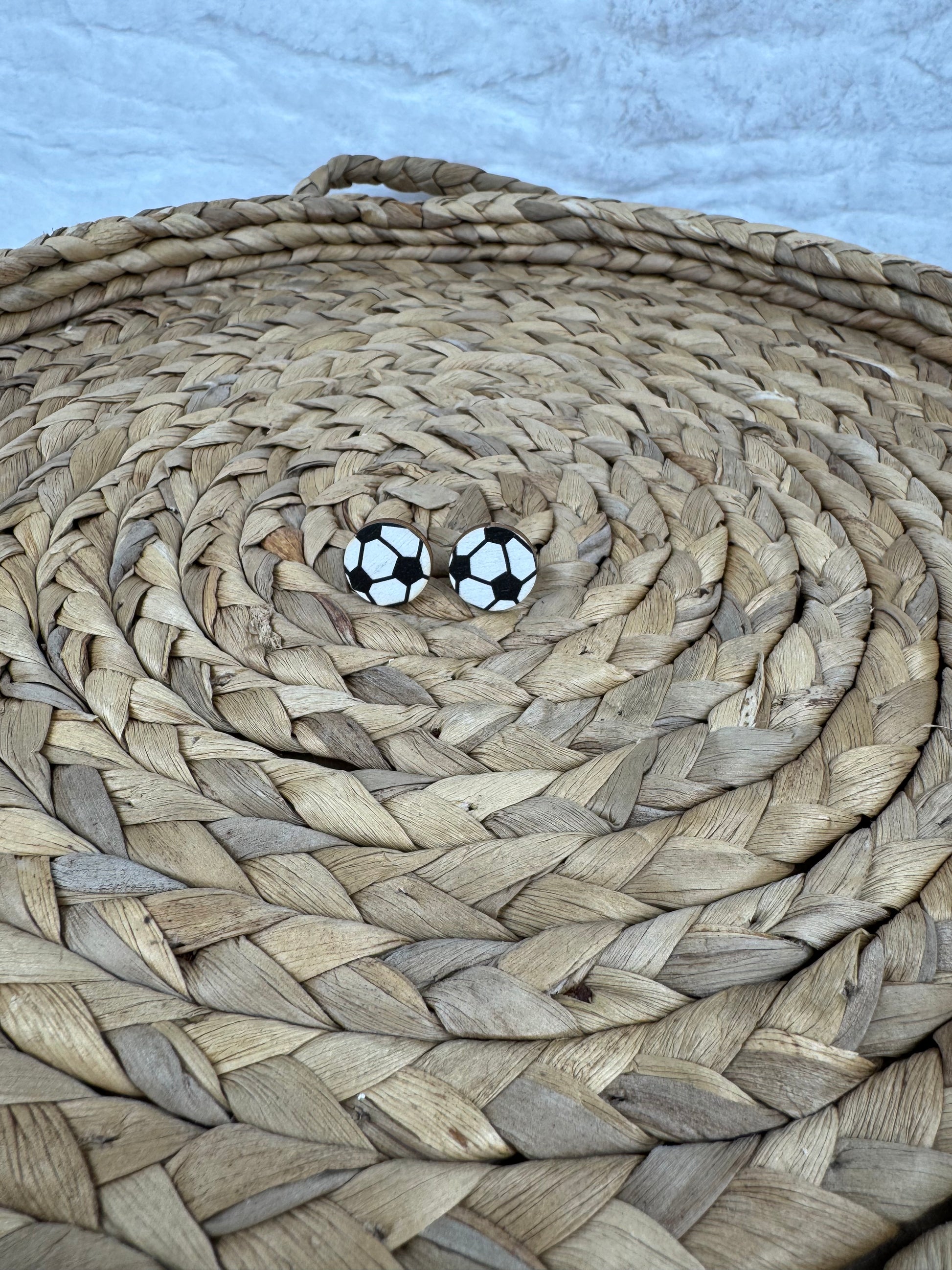 Soccer studs earrings on woven mat