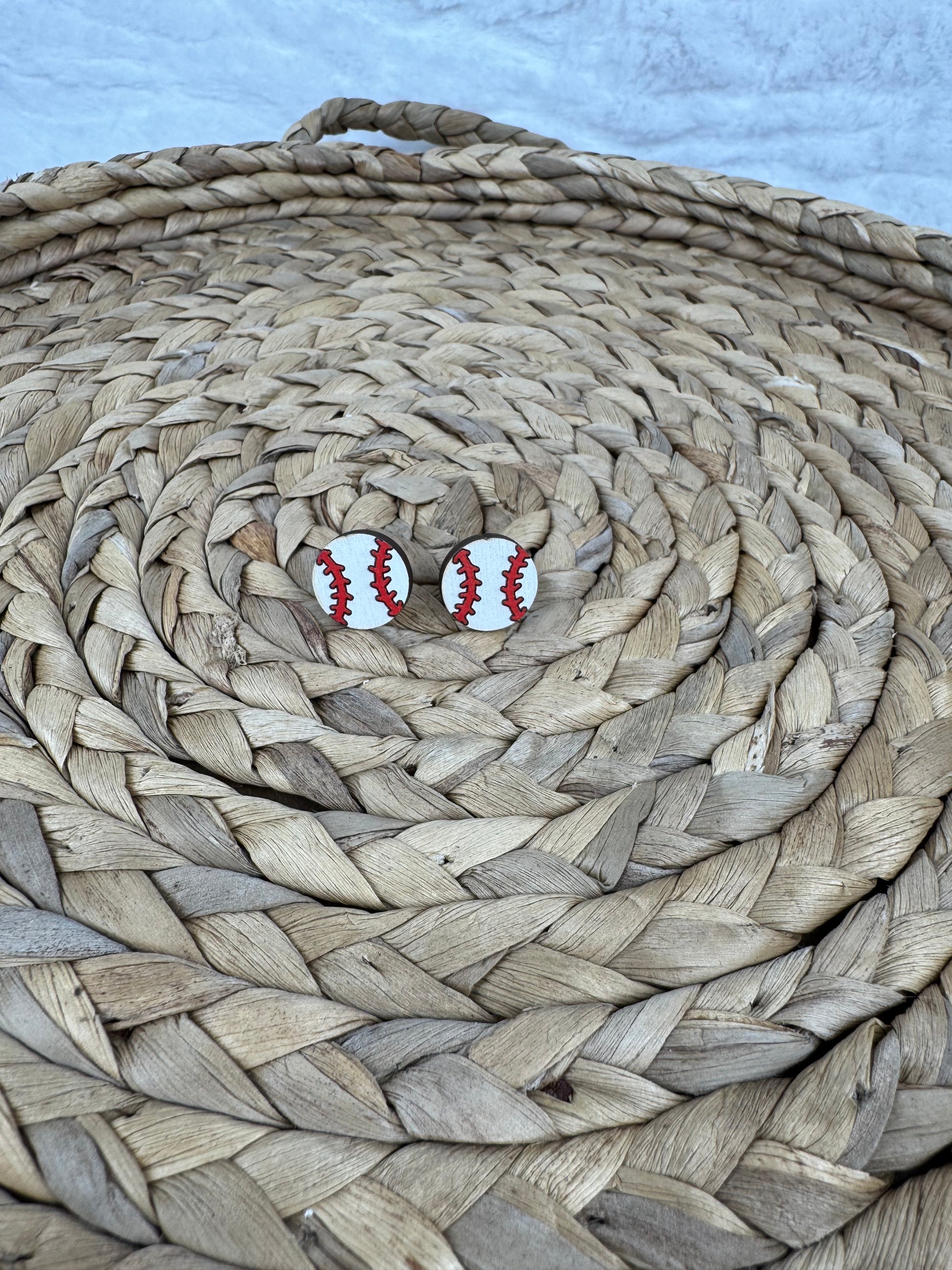 Baseball studs earrings on woven mat